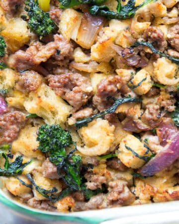 sausage stuffing with bits of broccoli rabe and red onion in a glass casserole