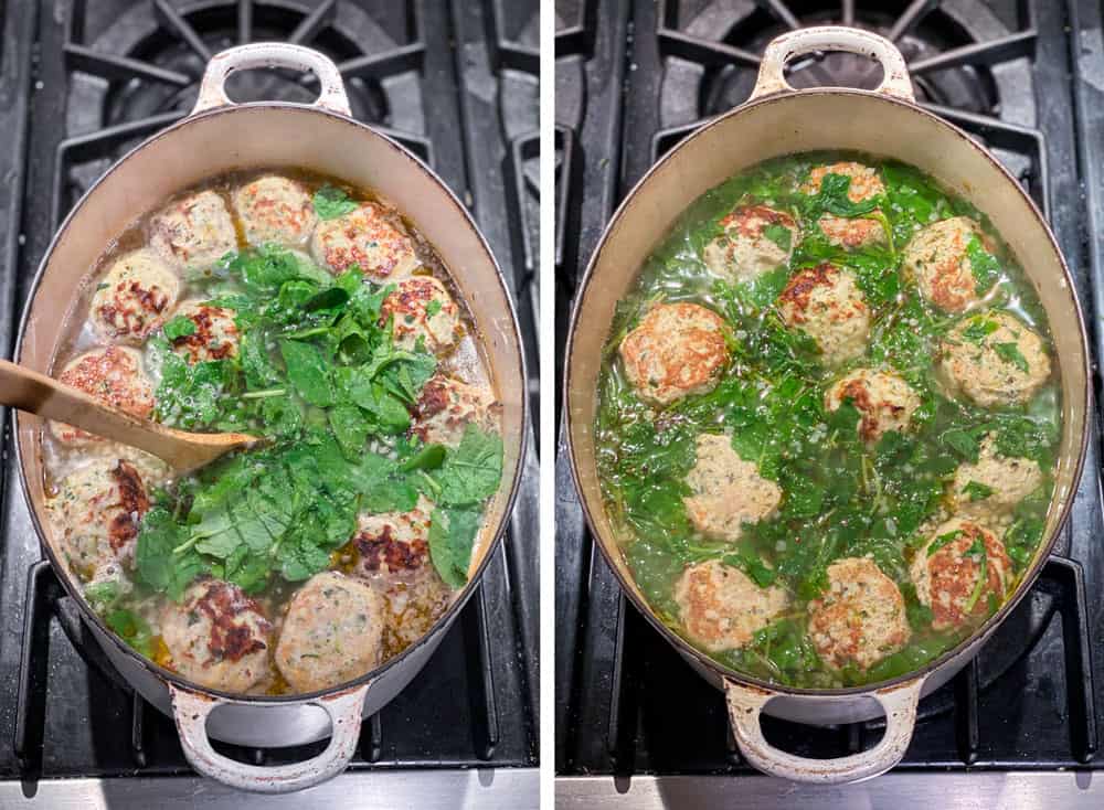 White Dutch oven seen from above as a pile of raw spinach is added to a pot of Italian wedding soup that's loaded with meatballs